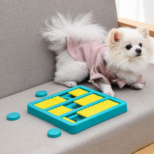 White dog playing with a blue treat puzzle.