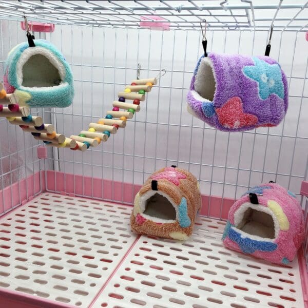 Colorful hanging beds in a pink cage.