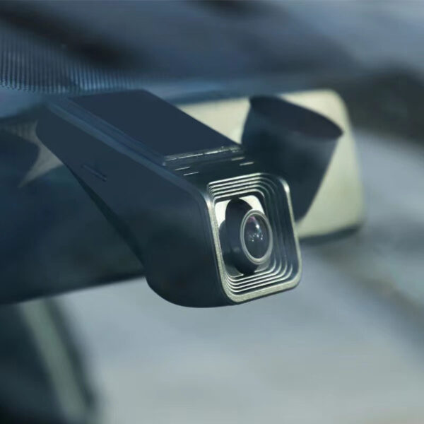 Black dashcam mounted on car windshield.