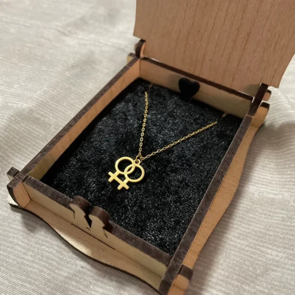 Gold lesbian symbol necklace in box.