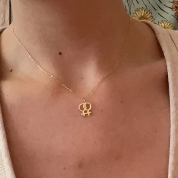 Gold necklace with lesbian symbol pendant.