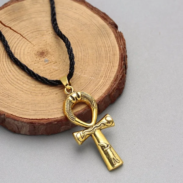 Gold ankh pendant on black cord necklace.