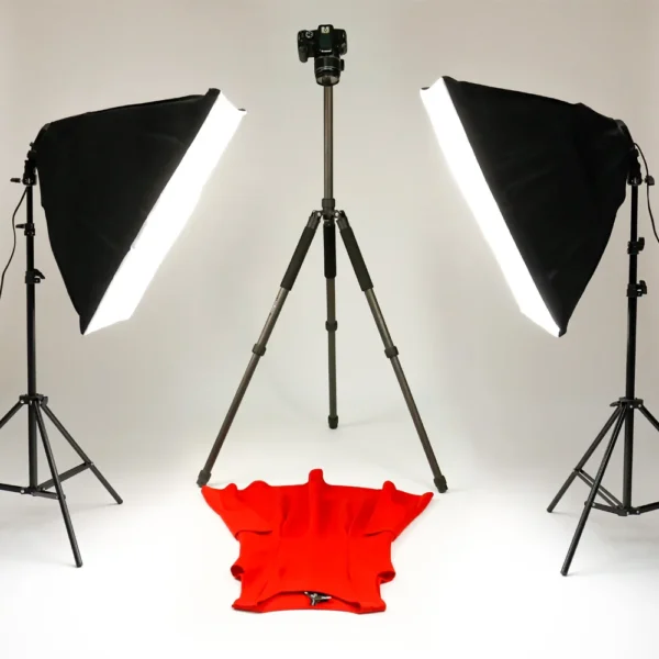 Red dress on tripod with lighting equipment.