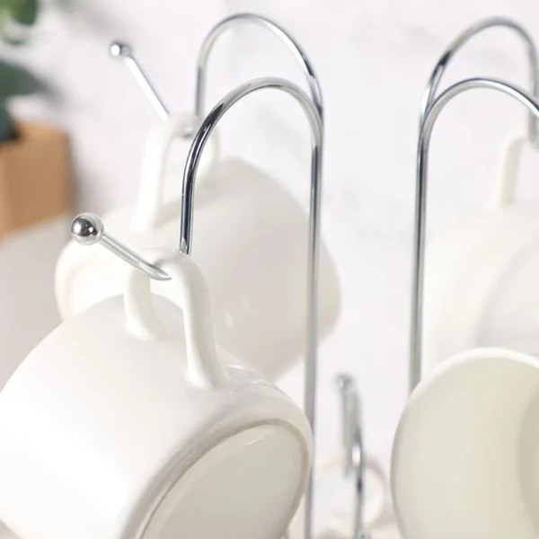 White mugs hanging on a chrome rack.