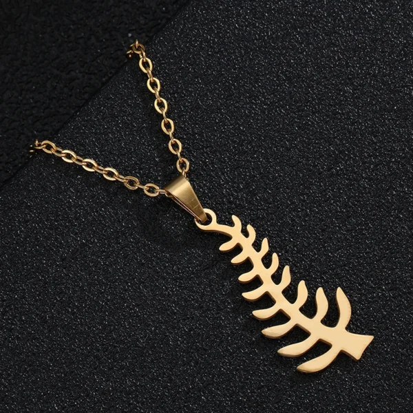 Gold necklace with fern pendant.