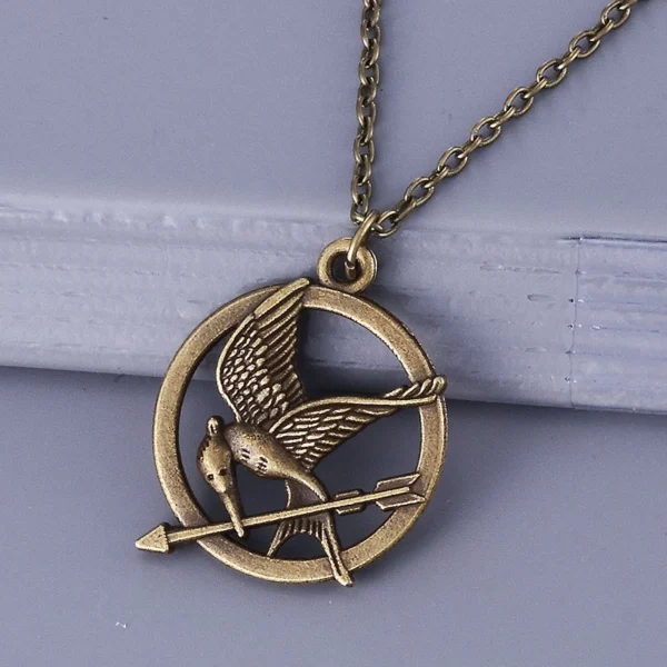 Bronze mockingjay necklace with arrow.