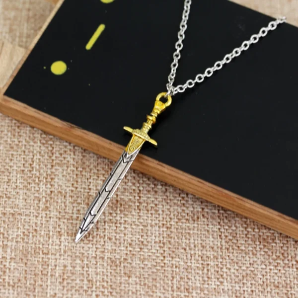 Silver and gold sword necklace on black background.