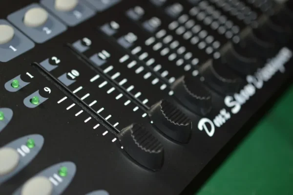 Black audio mixer with knobs and faders.