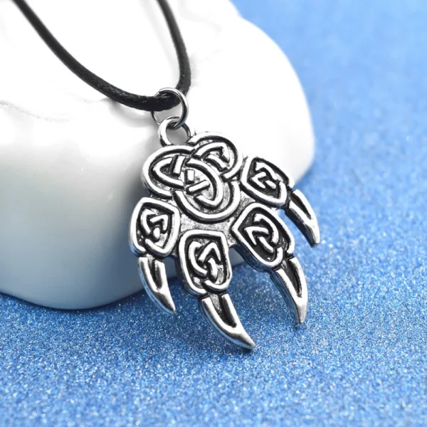 Silver Celtic knot paw print necklace.