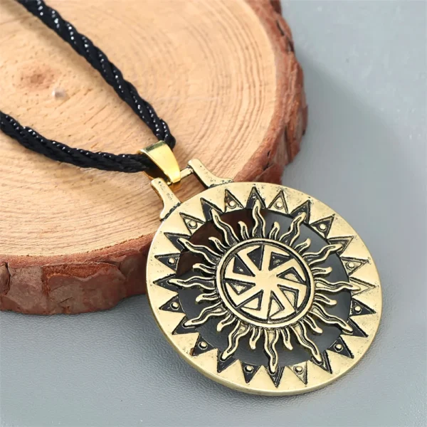 Gold sun pendant necklace with black cord.