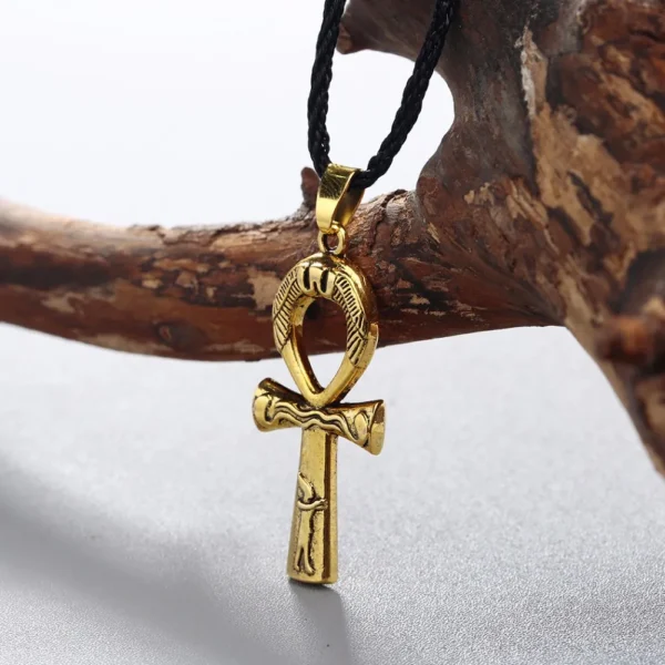 Gold ankh pendant on black cord necklace.