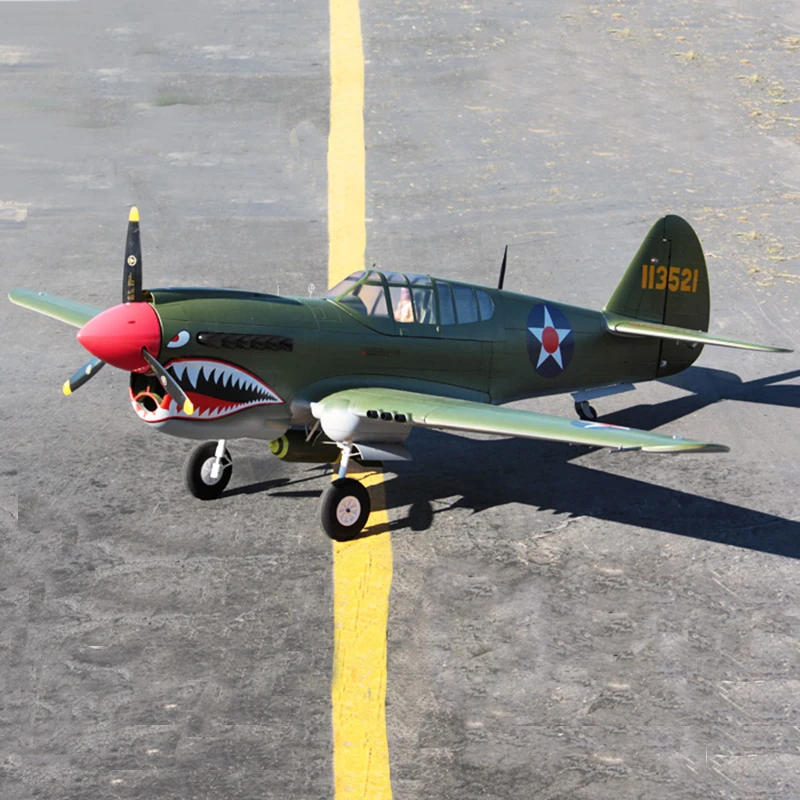 Green P-40 Warhawk airplane on tarmac.