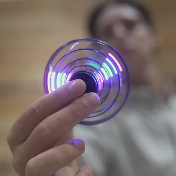 Hand spinning a glowing fidget spinner.