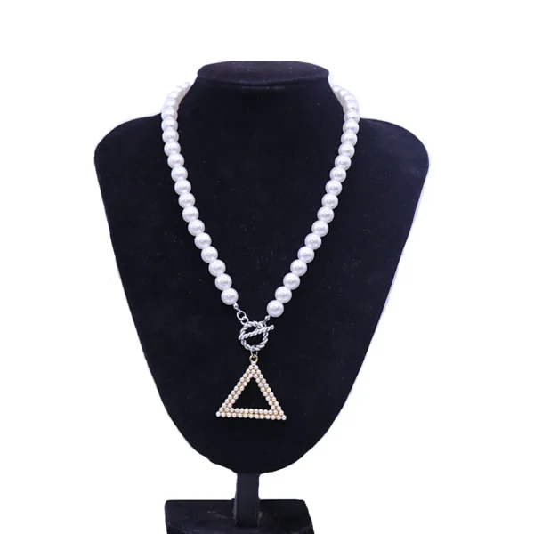 White pearl necklace with triangle pendant.