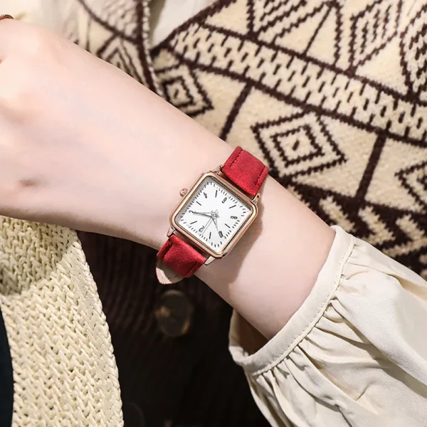 Red leather strap square watch on wrist.