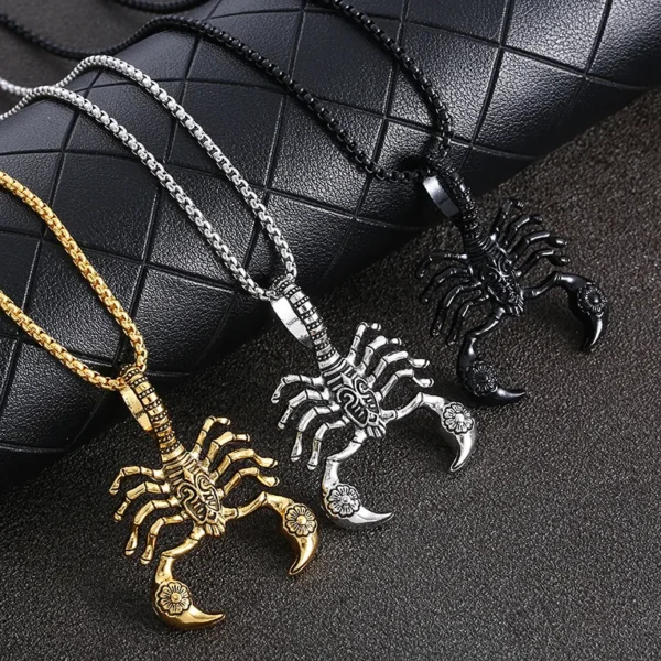 Three silver scorpion necklaces on black fabric.