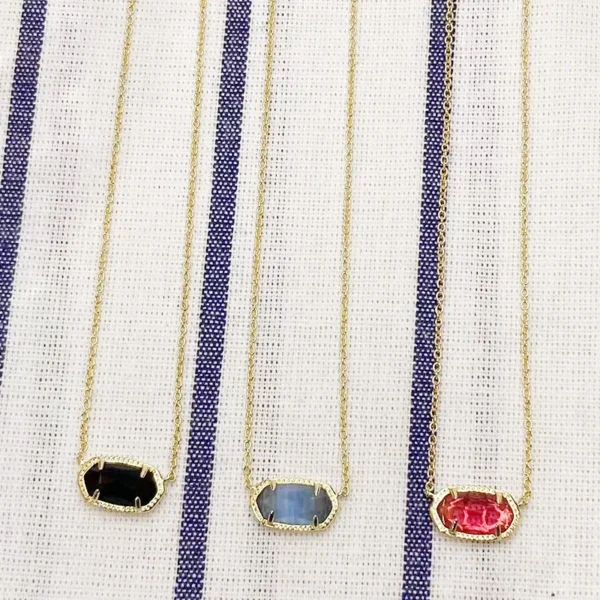 Three gold necklaces with gemstone pendants.