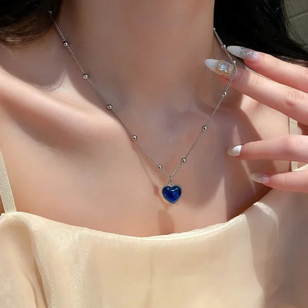 Silver necklace with blue heart pendant.