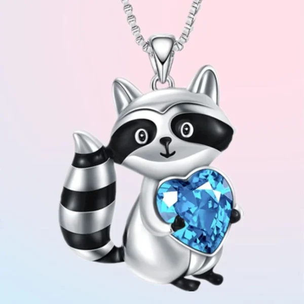 Silver raccoon necklace with blue heart charm.