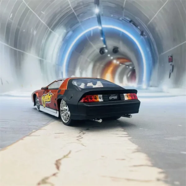 Black and orange toy car in tunnel.