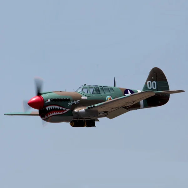 Green P-40 Warhawk airplane in flight.