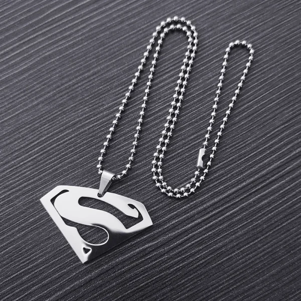 Silver Superman necklace on a wood background.