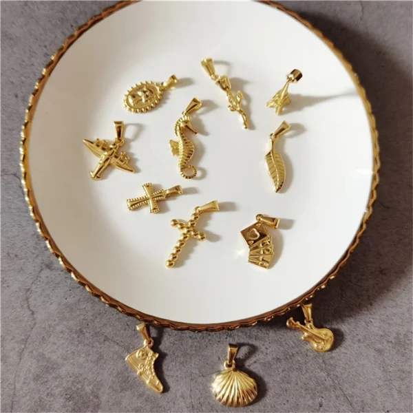 Gold charm pendants on a white plate.