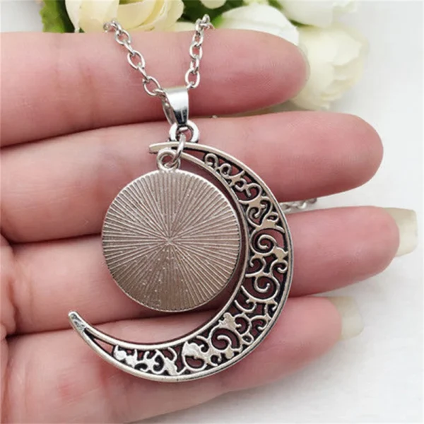 Silver crescent moon necklace with a round pendant.