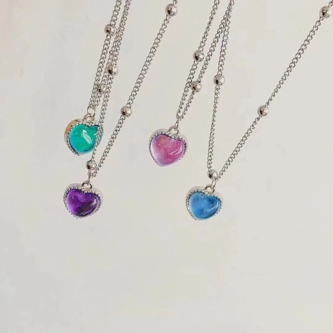 Four silver necklaces with heart charms.