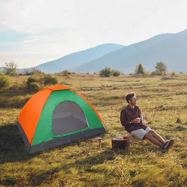 Orange and green camping tent in field.