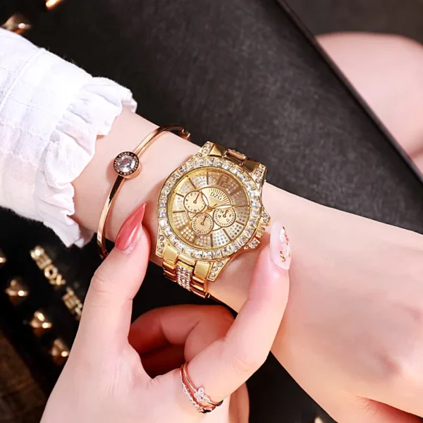 Gold watch with diamond accents on wrist.