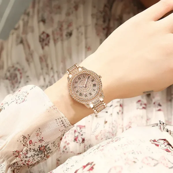 Diamond encrusted gold wristwatch on a woman's wrist.