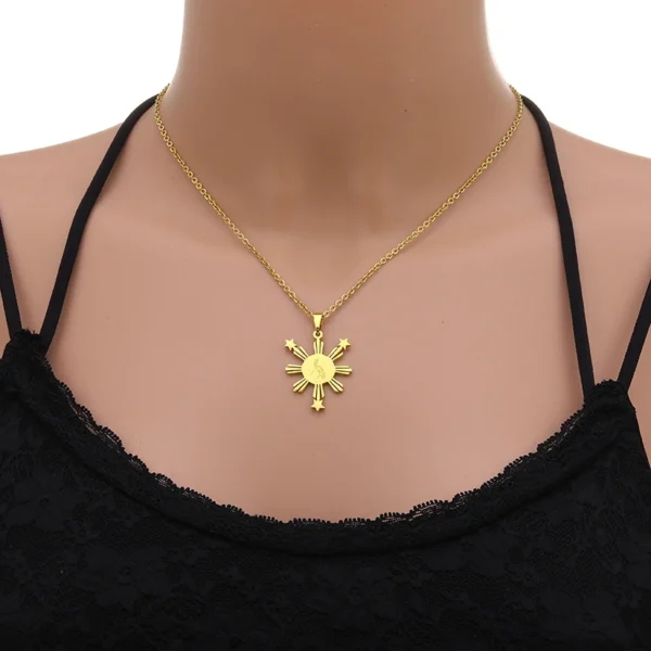 Gold necklace with sun and stars pendant.