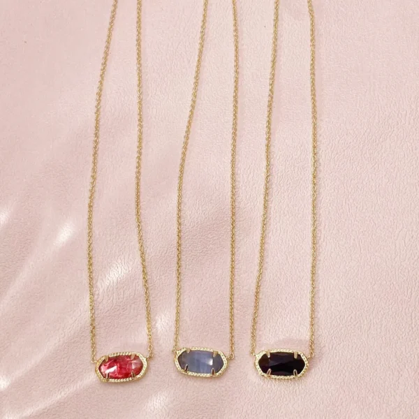 Three gold necklaces with colorful stones.