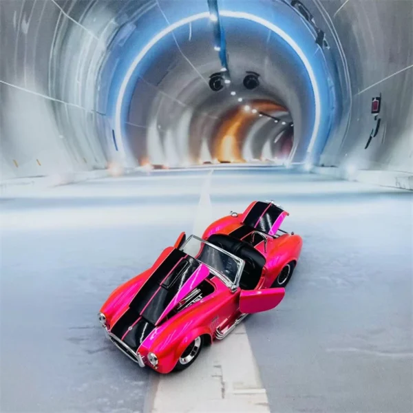 Pink and black toy car in tunnel.