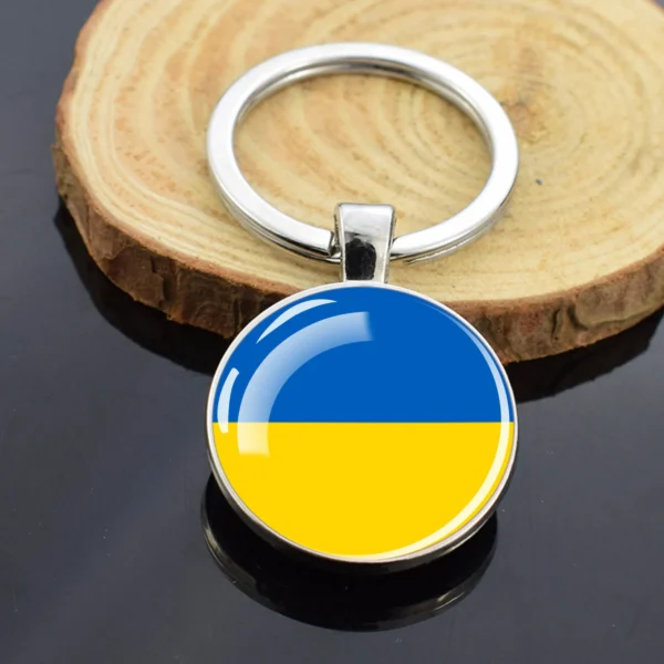 Ukrainian flag keychain on wood background.