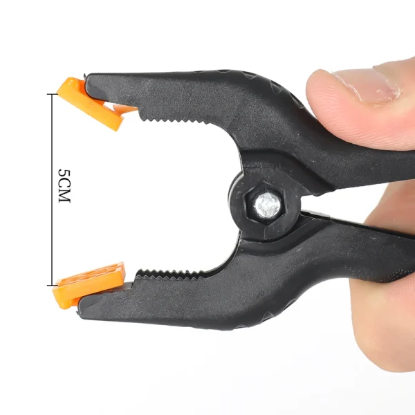 Black plastic clamp with orange pads.