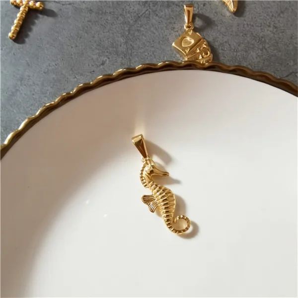 Gold seahorse pendant on white plate.