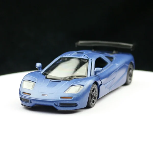 Blue McLaren F1 toy car on white background.