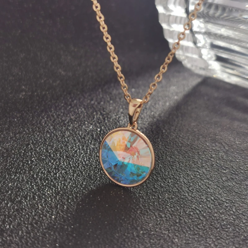 Rose gold chain with iridescent round pendant.