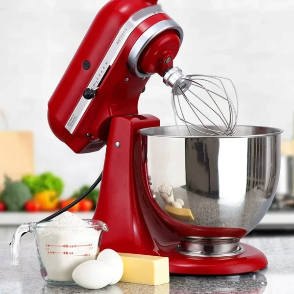 Red stand mixer with bowl and whisk.