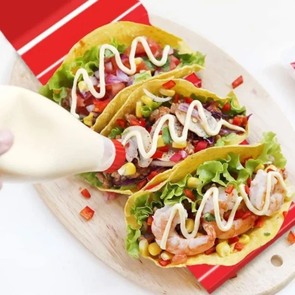 Three tacos with mayonnaise and toppings.