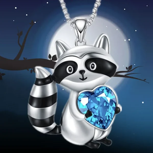 Silver raccoon necklace with blue heart pendant.