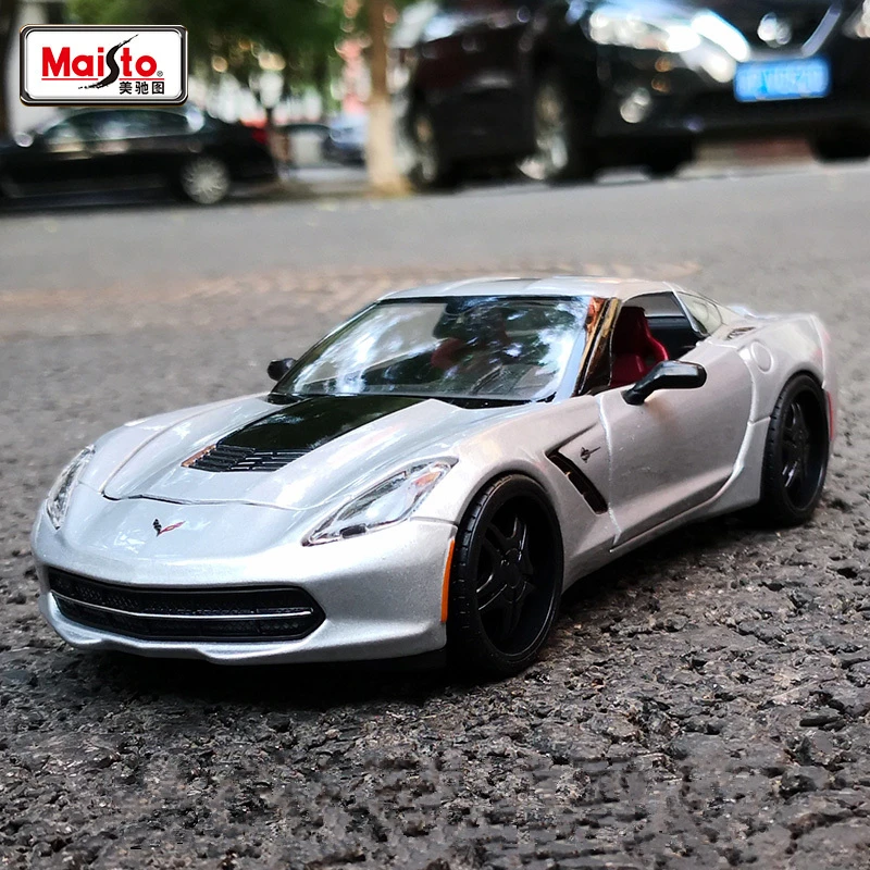 Silver Corvette toy car on asphalt.