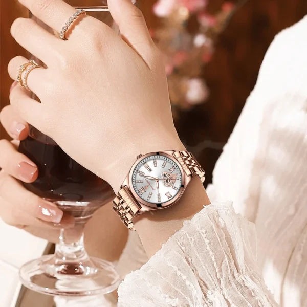 Woman's wrist wearing a rose gold watch.