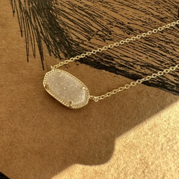 Gold chain with white stone pendant.