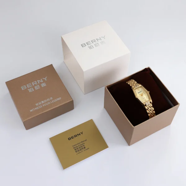 Gold watch in box with instruction manual.