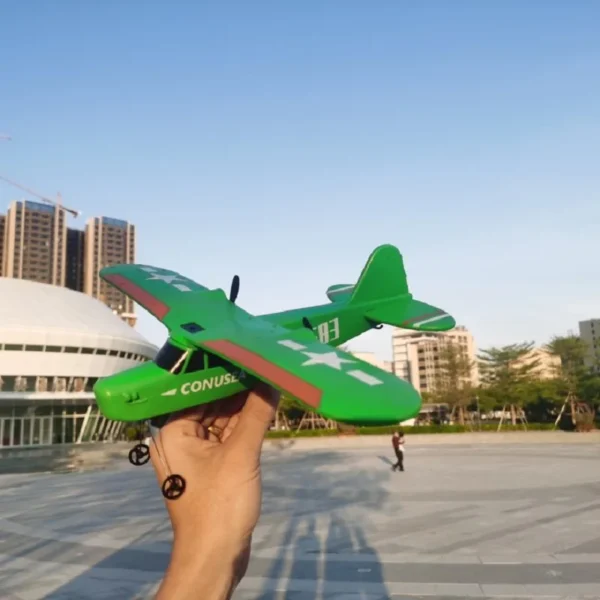 Green toy airplane held by hand.