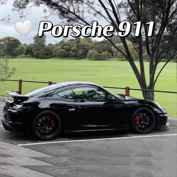 Black Porsche 911 parked in lot.