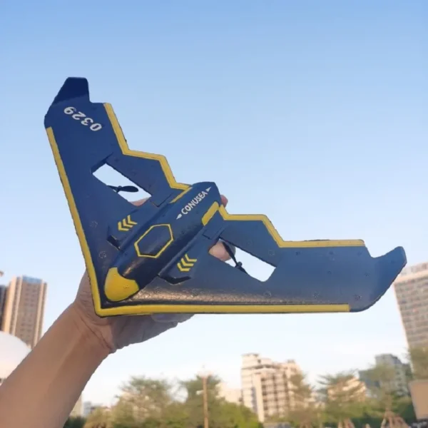 Blue and yellow toy airplane held in hand.